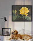 Framed canvas print of cactus bloom painting by Kris Horton hanging in a bedroom with a dog on the bed.
