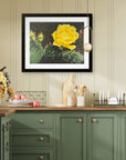 Beauty Among Thorns a cactus art print with a yellow flower painted by Kris Horton hanging in a kitchen with green cabinets