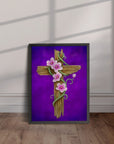 Black framed painting by Kris Horton of He is Risen a rustic cross with pink flowers and vine twisting around it and purple background leaning against a wall.