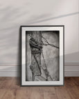 Black framed wall art by Kris Horton of an old wooden fencepost wrapped with barb wire.