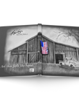 Open journal showing a black and white illustration of a barn with an American flag and a pickup truck, painting by Kris Horton