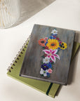 Cross made of vibrant flowers painting by Kris Horton on a journal cover