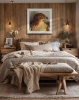 Oak framed painting by Kris Horton of a close up of a red tailed hawk hanging in a cozy bedroom.