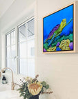 Framed canvas print of Sea of Colors, a painting by Kris Horton, a vibrant sea turtle swimming in the ocean.