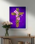 Framed artwork of a rustic wooden cross with pink flowers on a purple background, displayed above a wooden shelf.
