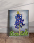 White framed bluebonnet painting by Kris Horton leaning on a wall.