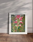 White framed floral painting by Kris Horton of an Indian Paintbrush leaning against a wall.