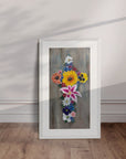 White framed Cross in Bloom painting by Kris Horton displayed leaning against a wall.