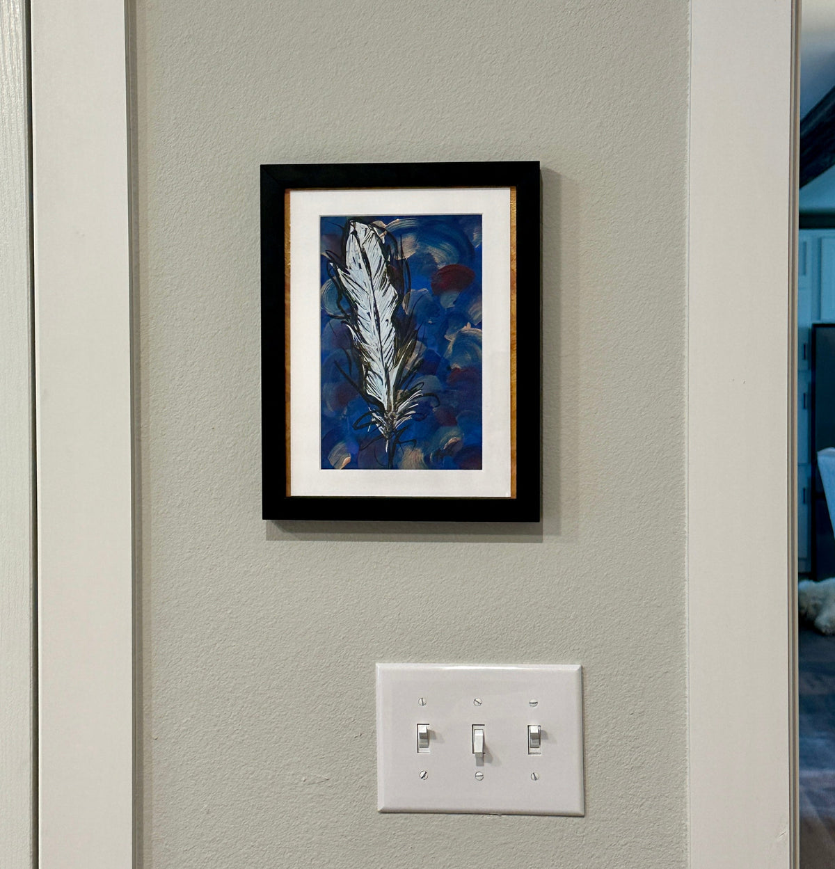 A Feathered Thought painting by Kris' Artworks hanging on a wall.