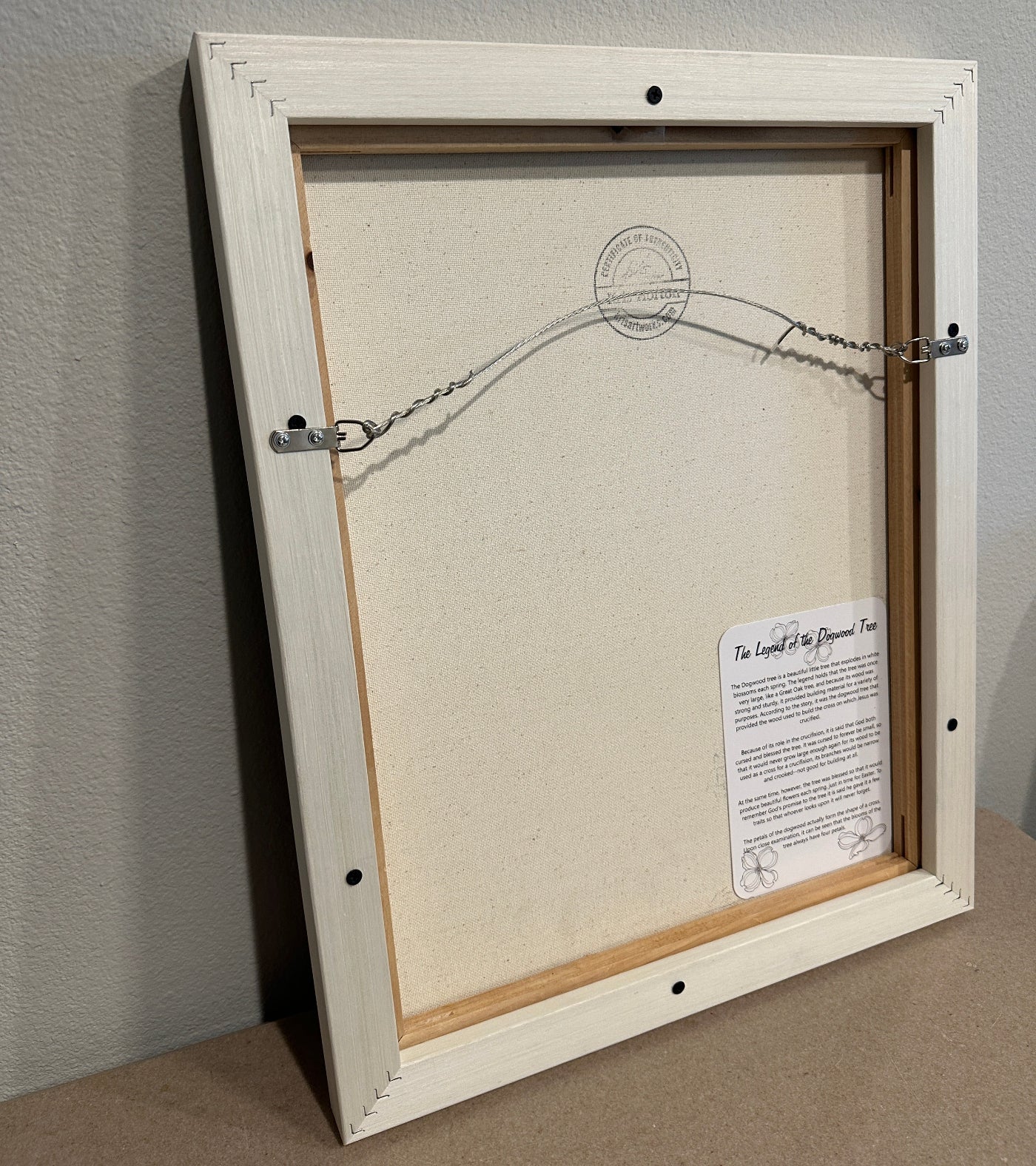 Back of framed painting the dogwood by Kris Horton with 'the legend of the dogwood' attached to the back