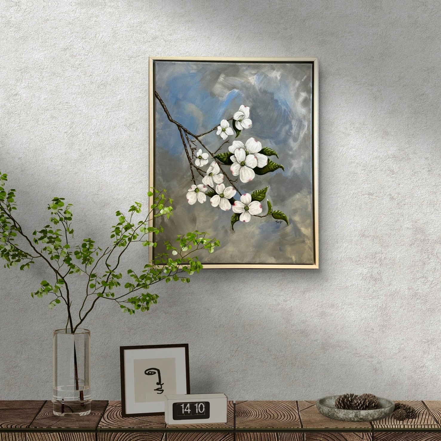 Framed painting by Kris Horton of white flowers on a textured wall above a wooden console table.