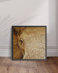 Framed artwork by Kris Horton of an elephant's head leaning on a wall with wooden flooring.