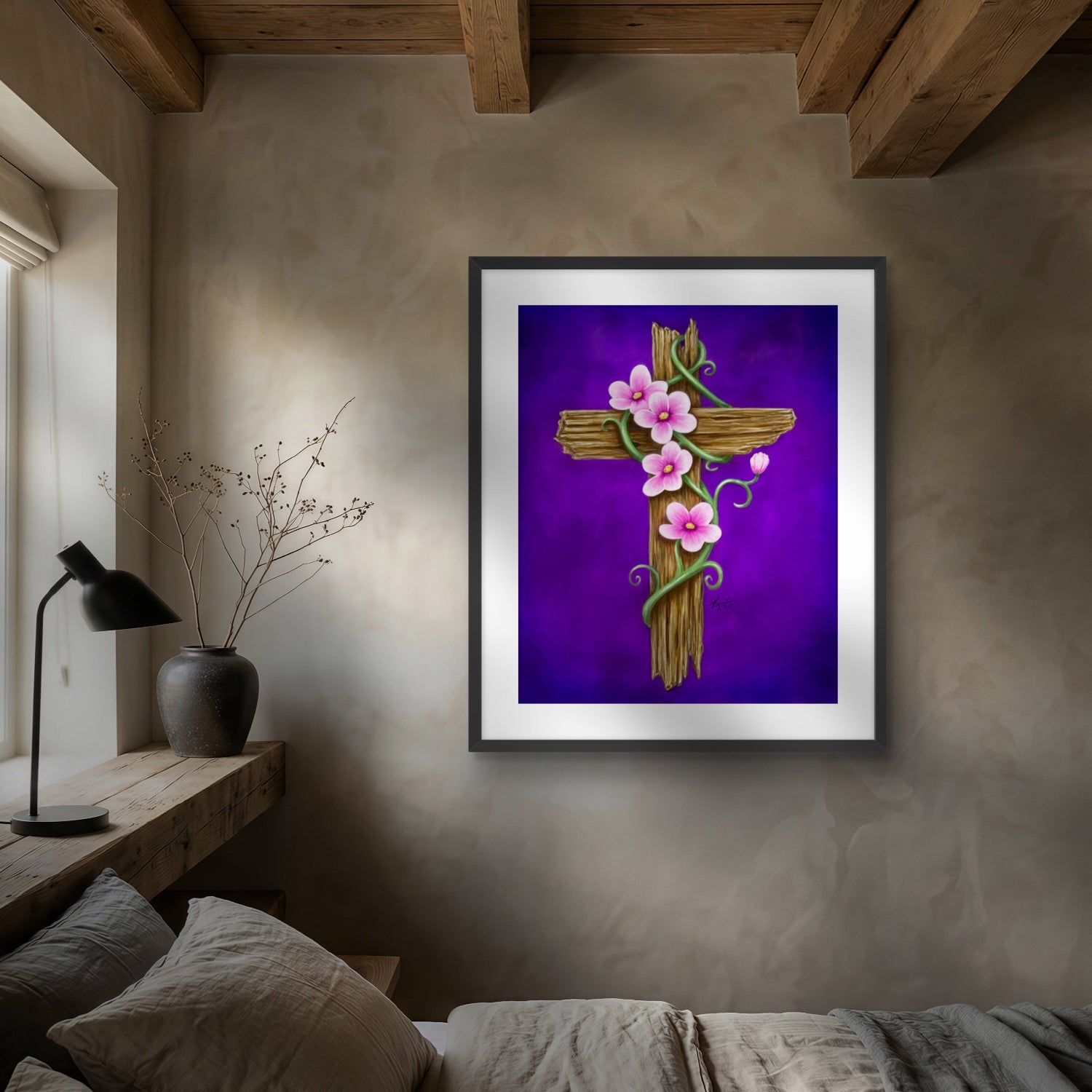 Framed artwork by Kris Horton of a rustic cross with flowers on a wall above a bed in a bedroom.
