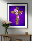 Framed artwork of He is Risen a cross with flowers on a purple background, displayed above a wooden shelf.