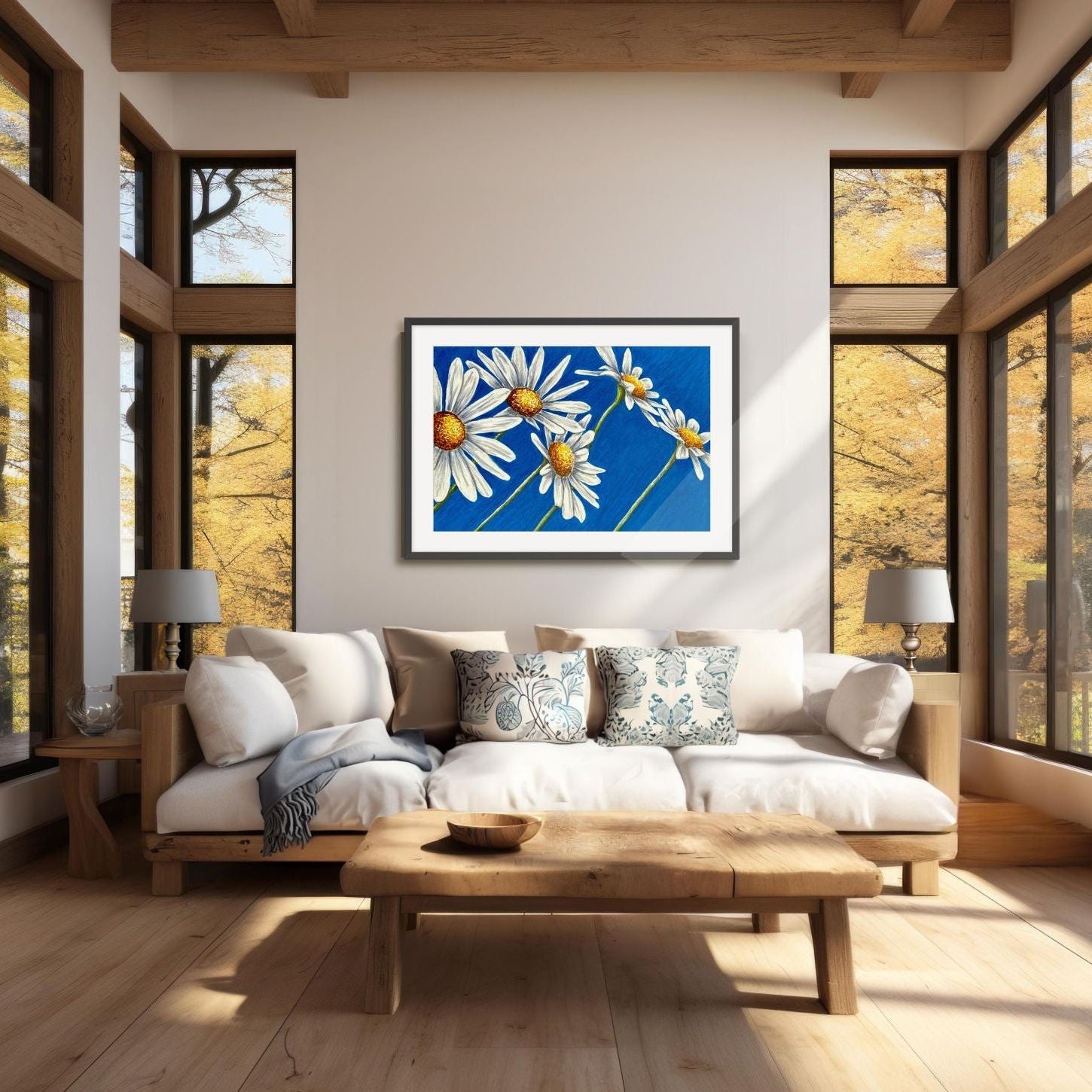 Daisy days black framed painting by Kris Horton above a couch in living room with large windows