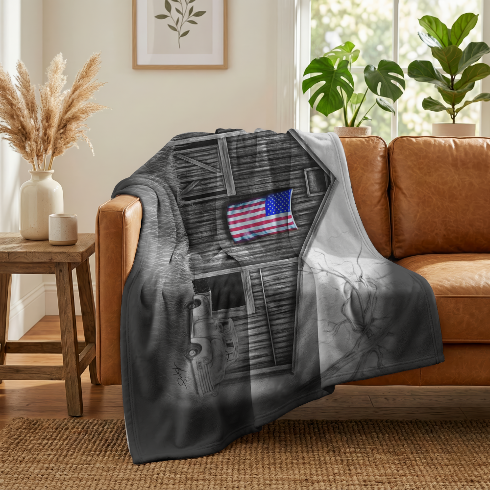 My America painting by Kris Horton printed on a fleece blanket draped over a leather couch