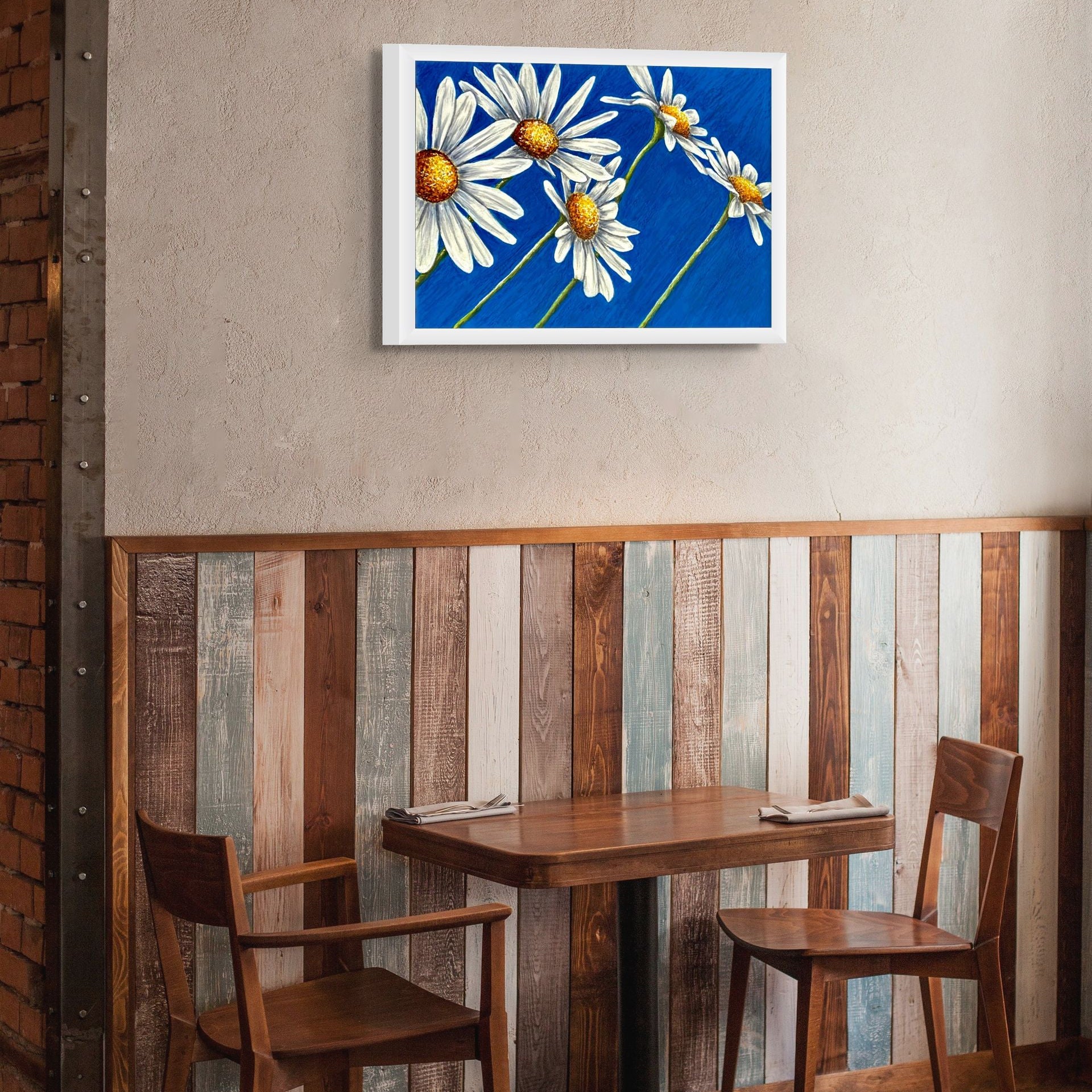 Daisy Days framed canvas print, a painting by Kris Horton, hanging over a table.
