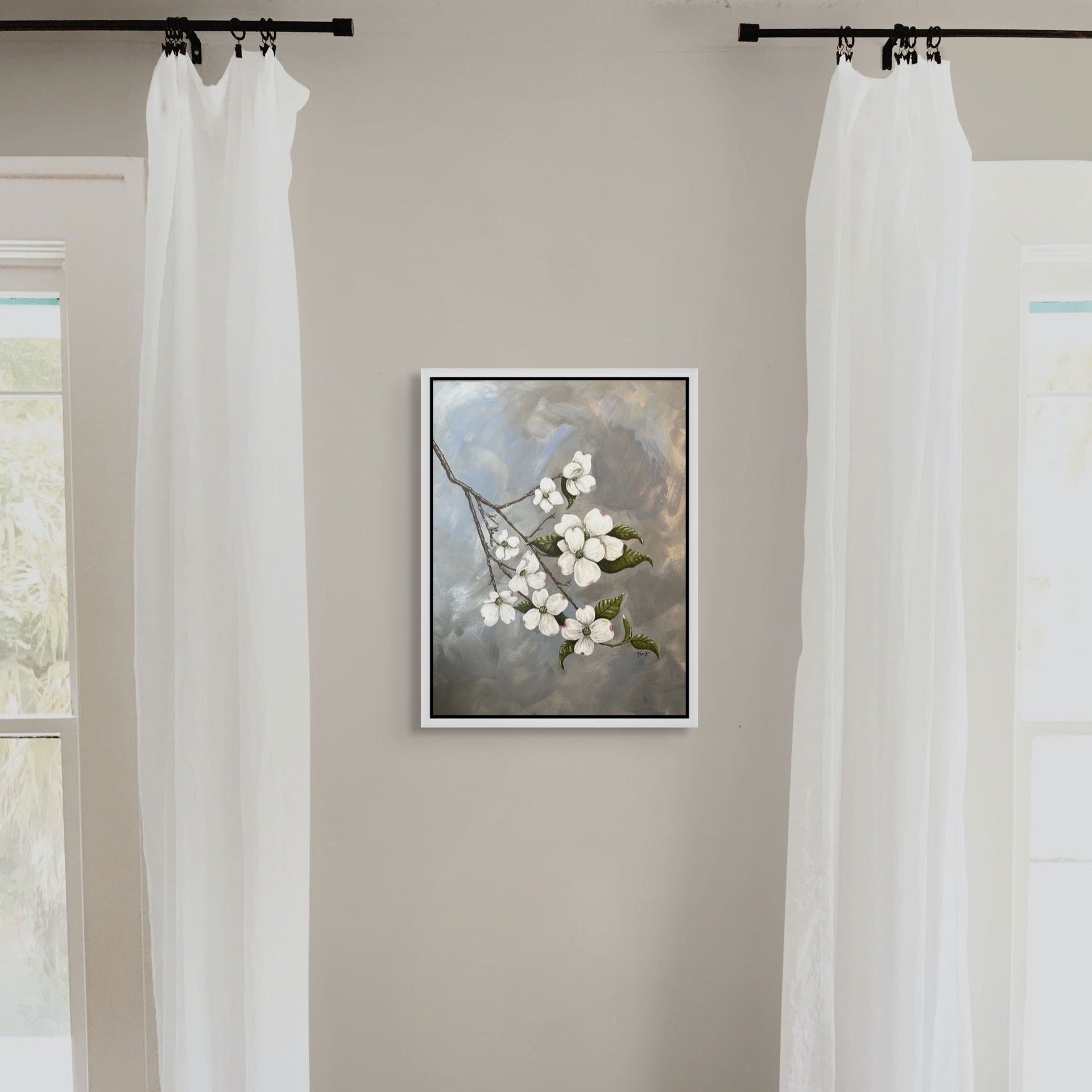 Framed artwork by Kris Horton of a floral branch on a wall between two white curtains.