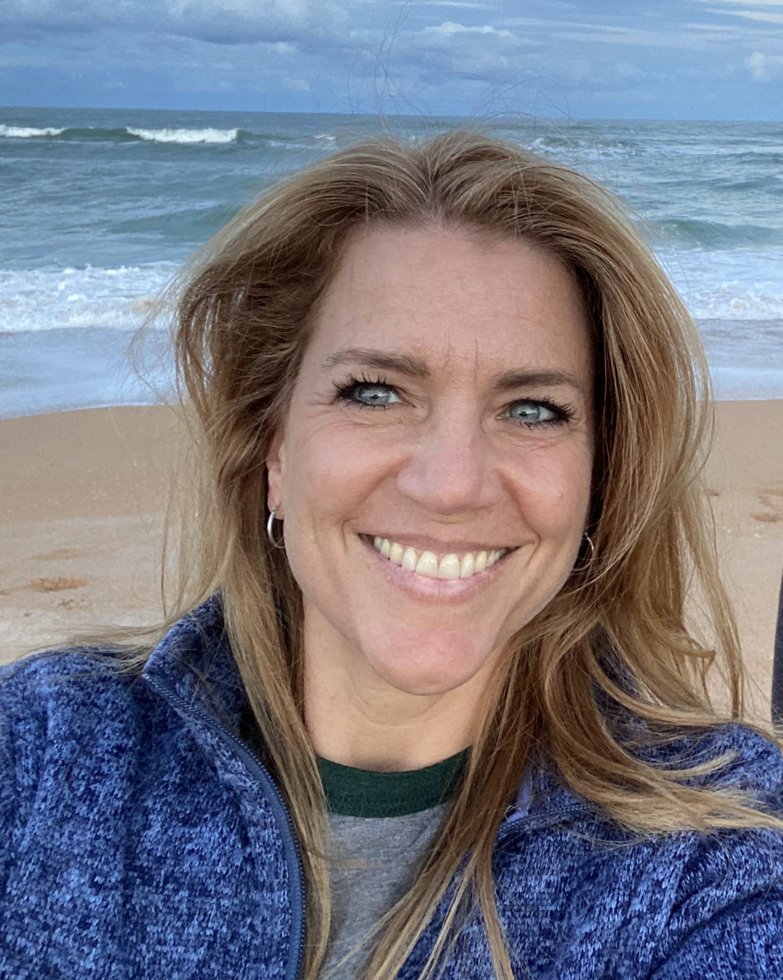 Kris Horton, the artist smiling on the beach