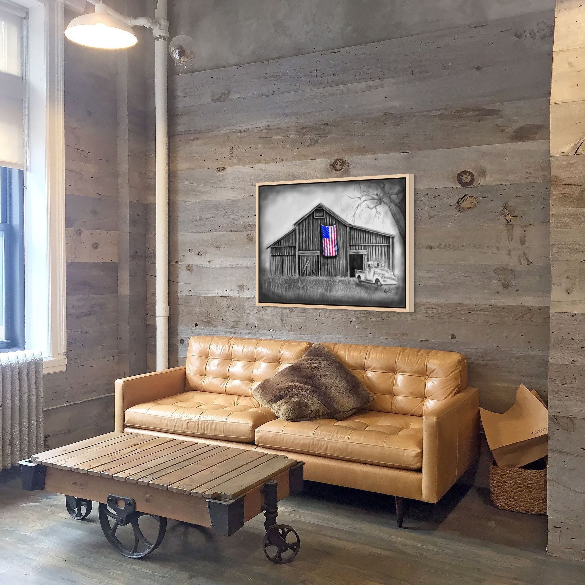 My America painting by Kris Horton hanging on a living room wall, Americana painting of an old barn, old chevy truck, with an American Flag.