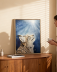 Framed painting by Kris Horton of a bobcat on wooden console with woman looking at it.