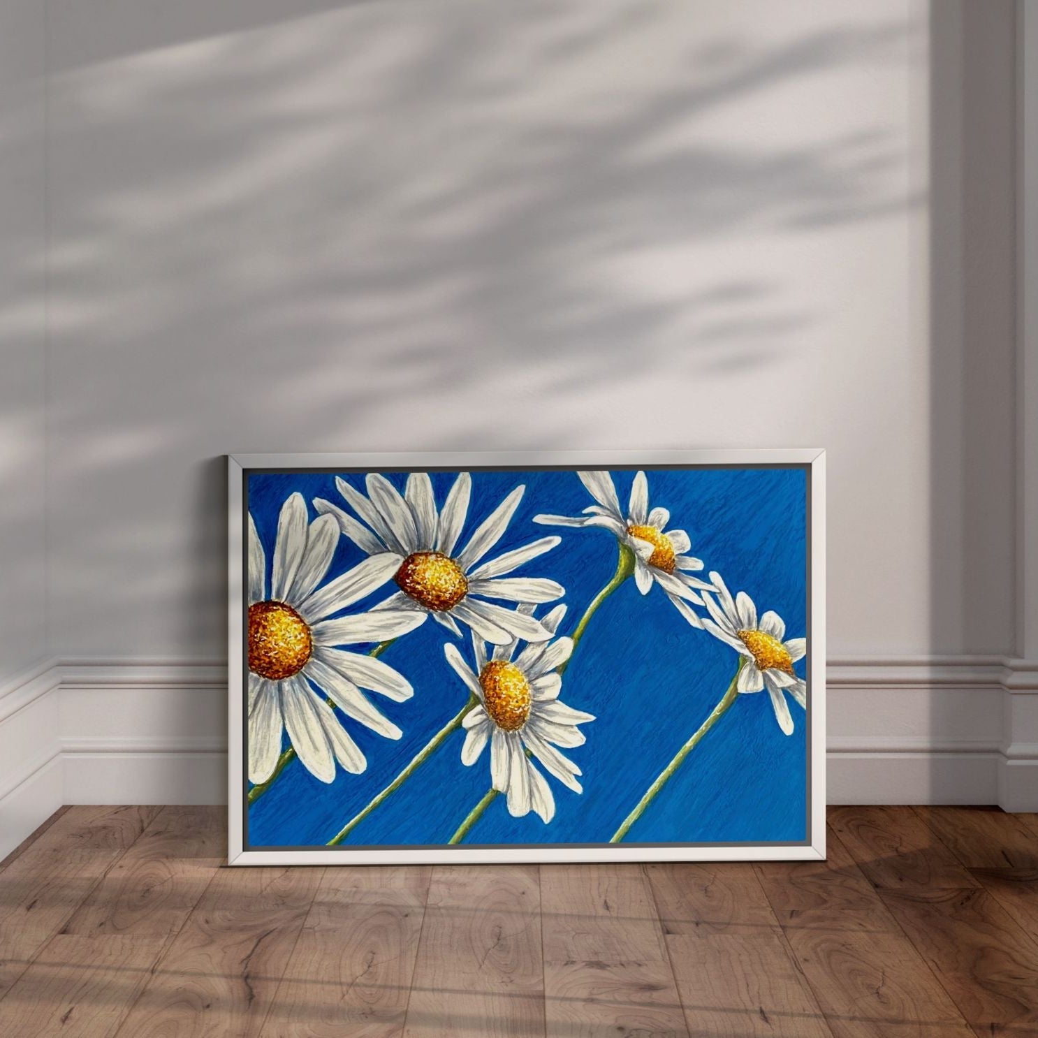 White framed Daisy Days daisy painting by Kris Horton with blue background wall art.