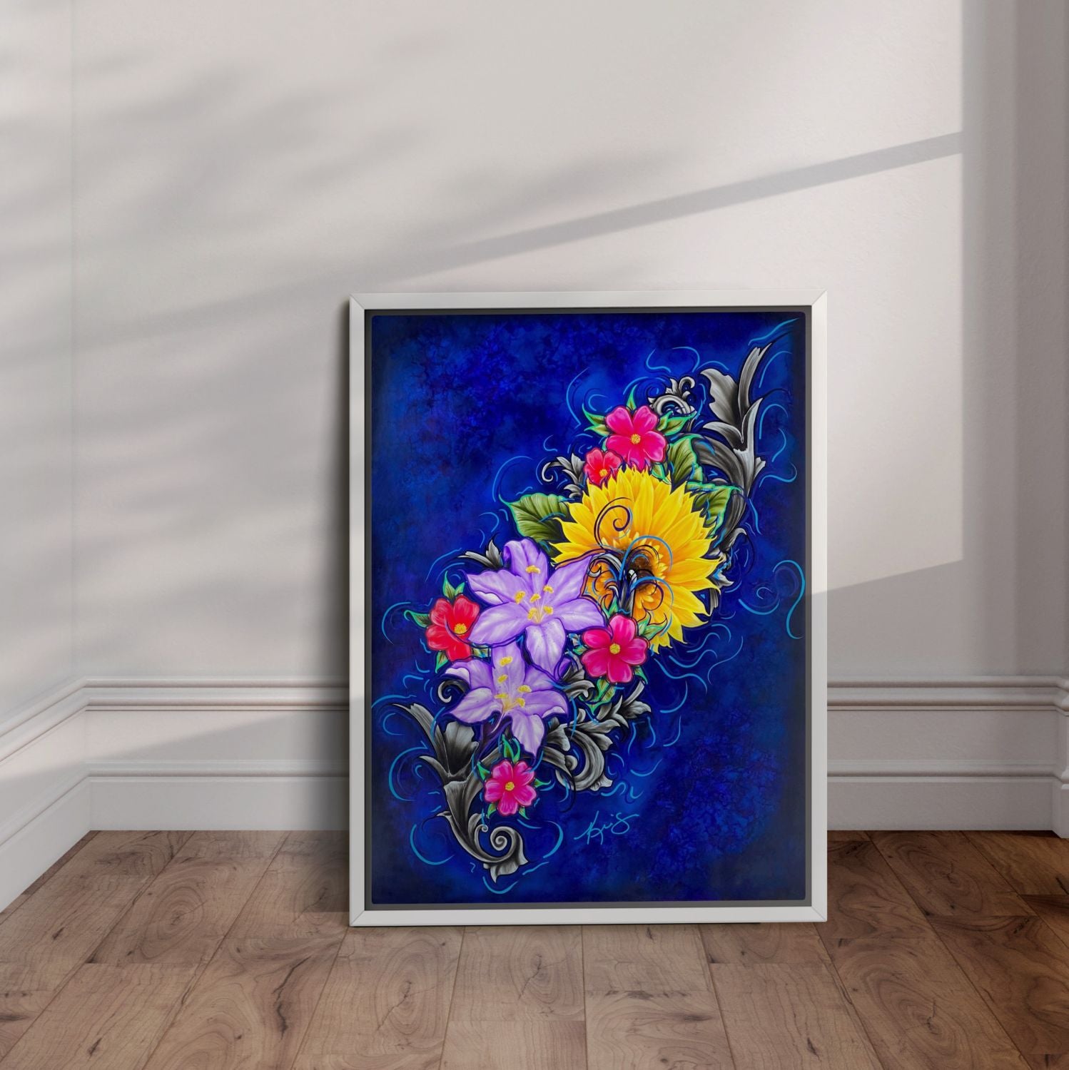 White framed painting of vibrant flowers and blue background leaning against a wall.
