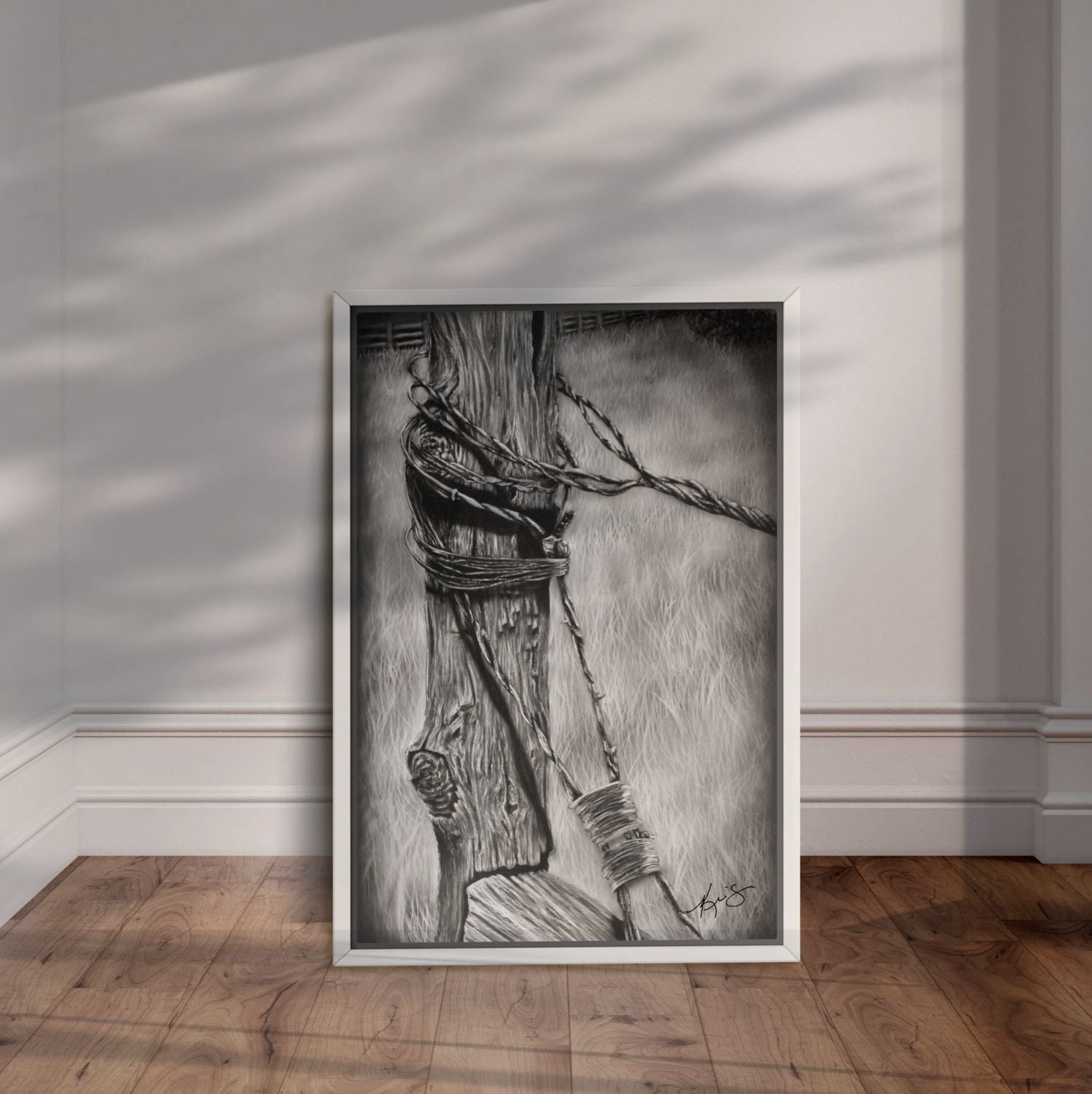White framed black and white artwork Bound of an old fence post bound with barb wire