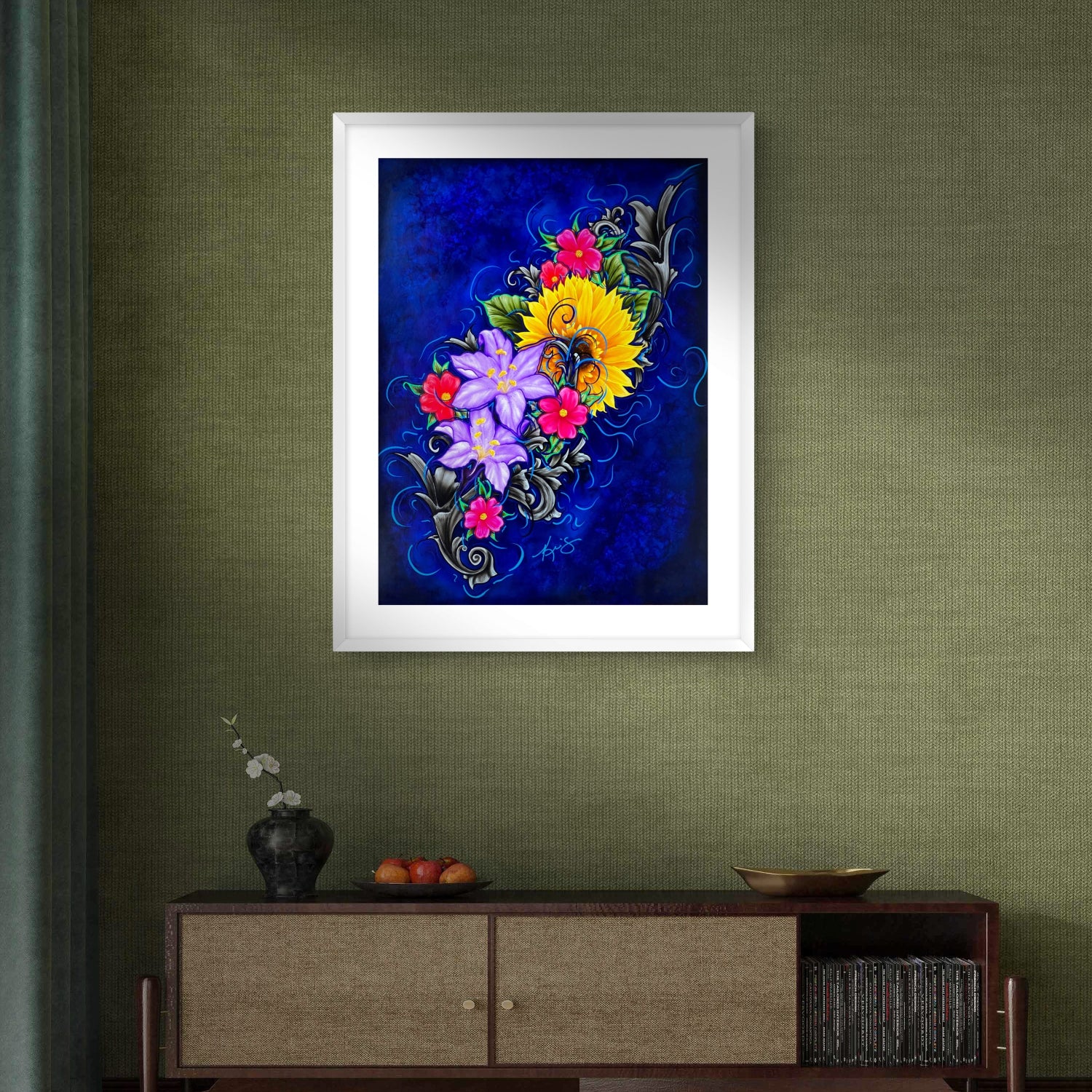 Framed artwork of colorful flowers on a green wall above a wooden cabinet.