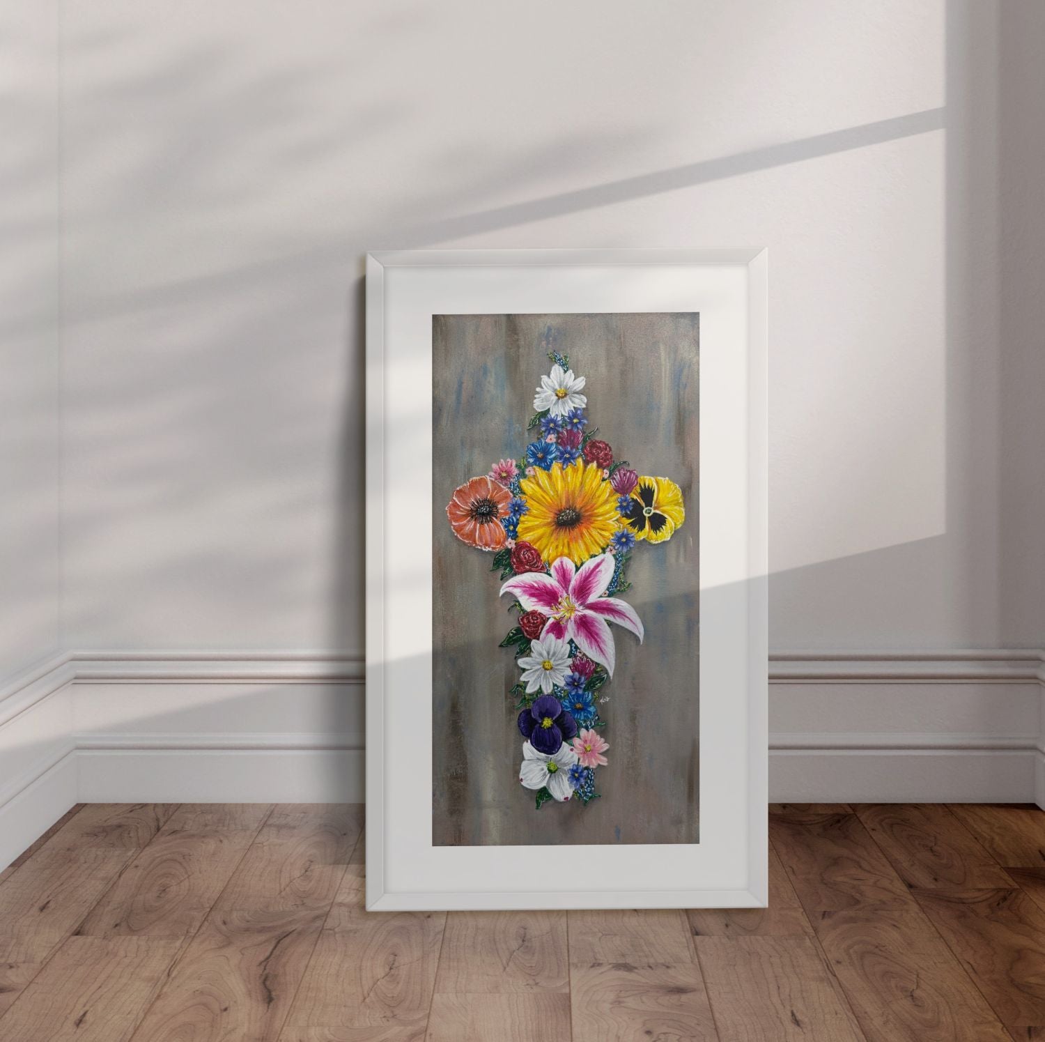 White framed Cross in Bloom painting displayed leaning against a wall.