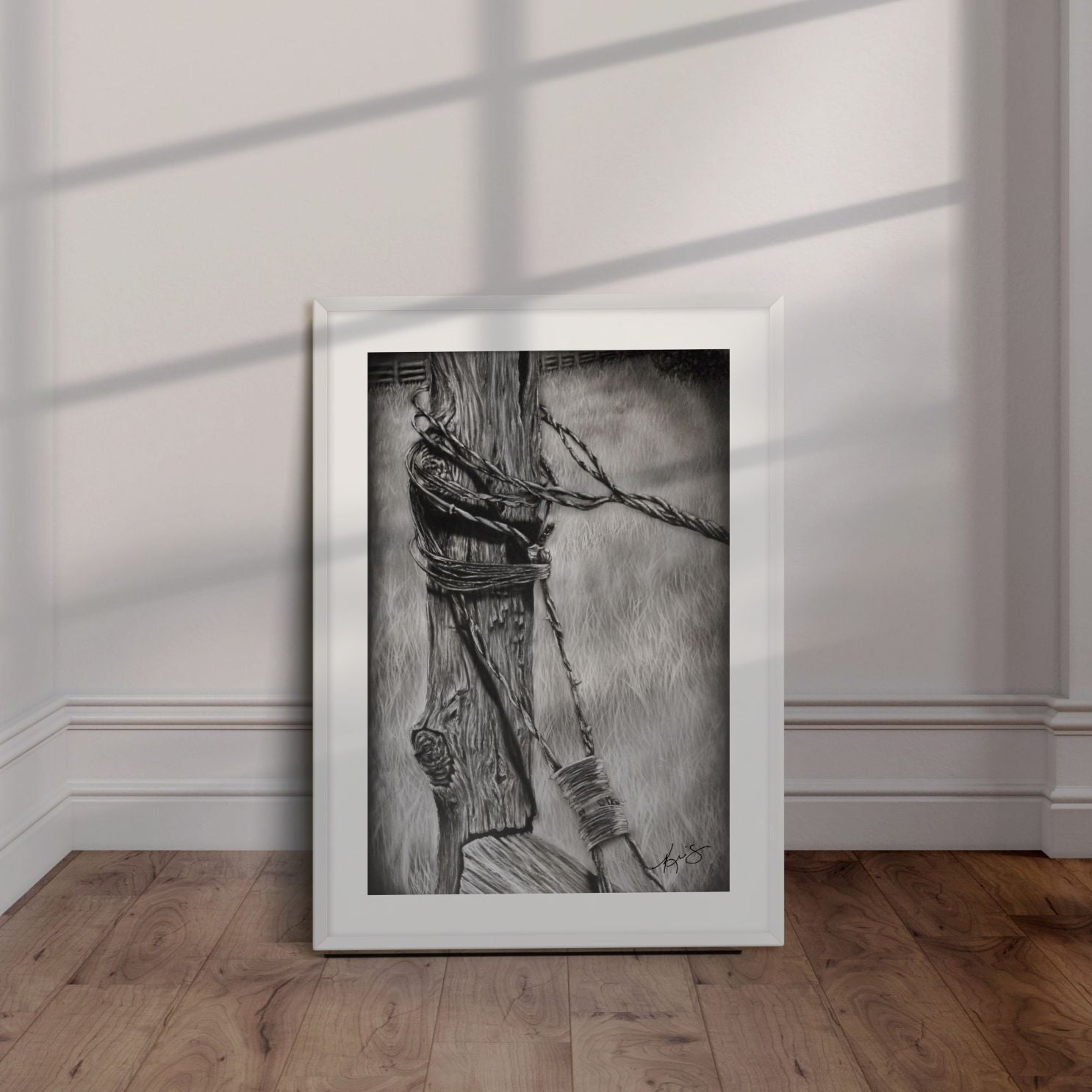 White framed artwork by Kris Horton of an old fencepost with barb wire.